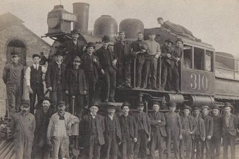 P&R Employees posed for this group photograph in front of a Camelback locomotive.